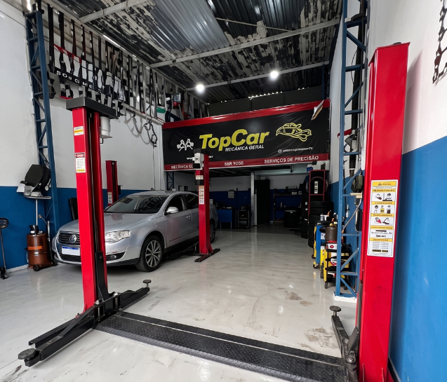 Interior da oficina com os dois elevadores e o banner da Top Car