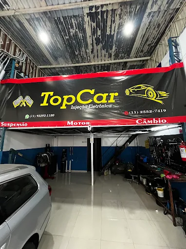Interior da oficina Top Car, com o banner da empresa sobre o elevador
